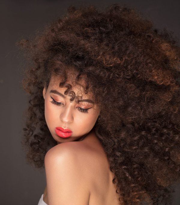 Beauty portrait of attractive african american woman with long afro hairstyle and glamour makeup, studio shot.
